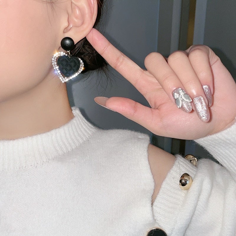 Boucles d'oreilles en or avec un cœur sombre